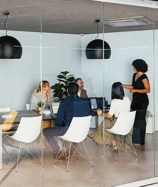 Two women seated at a table in a modern office setting.